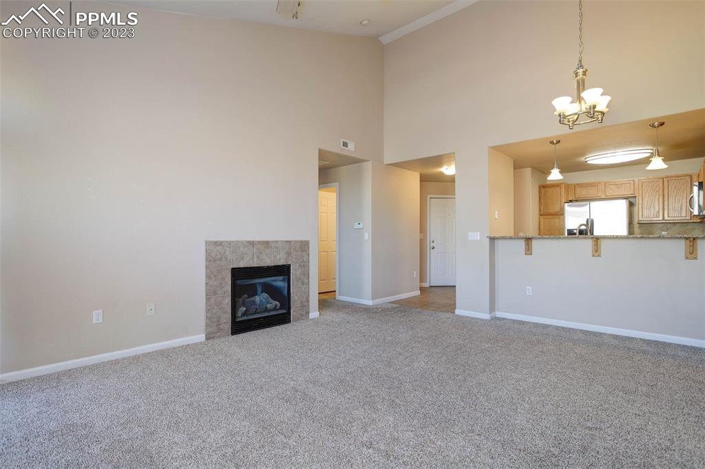 605 Cougar Bluff Point, Unit 210 Colorado Springs, CO 80906 - Photo 18 of 33 an empty room with a fireplace and fan