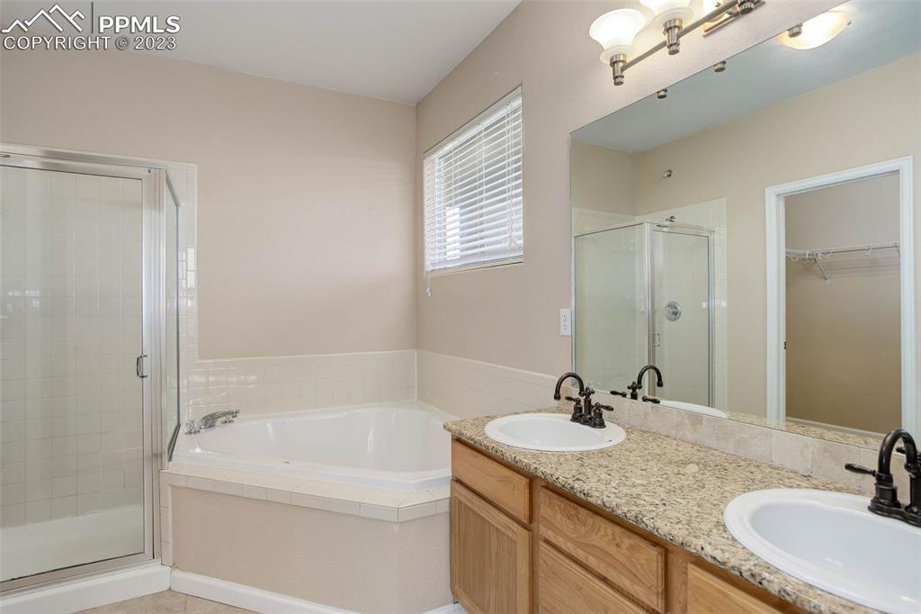 605 Cougar Bluff Point, Unit 210 Colorado Springs, CO 80906 - Photo 24 of 33 a bathroom with a granite countertop sink mirror and a bathtub