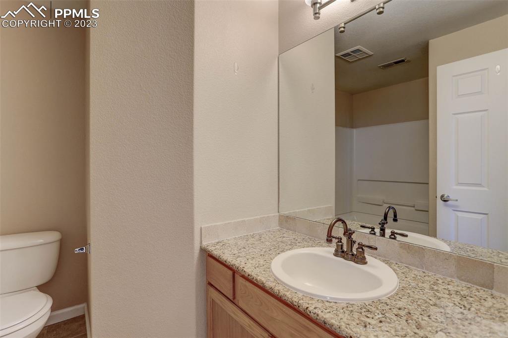 605 Cougar Bluff Point, Unit 210 Colorado Springs, CO 80906 - Photo 30 of 33 a bathroom with a granite countertop sink toilet and shower