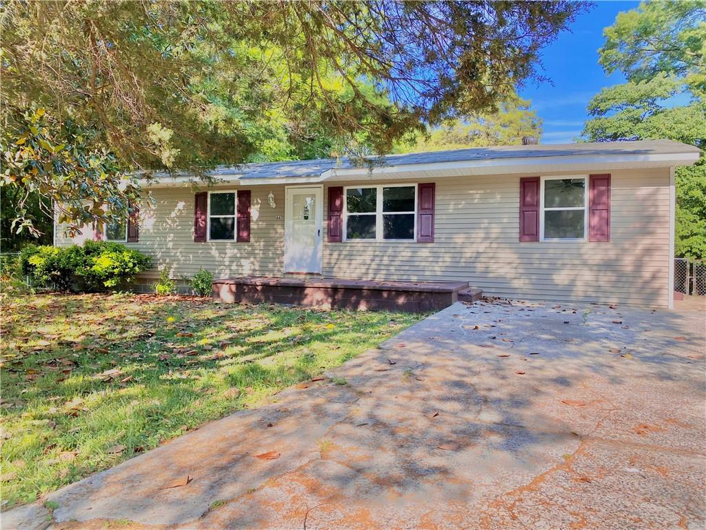 a front view of house with yard and trees around