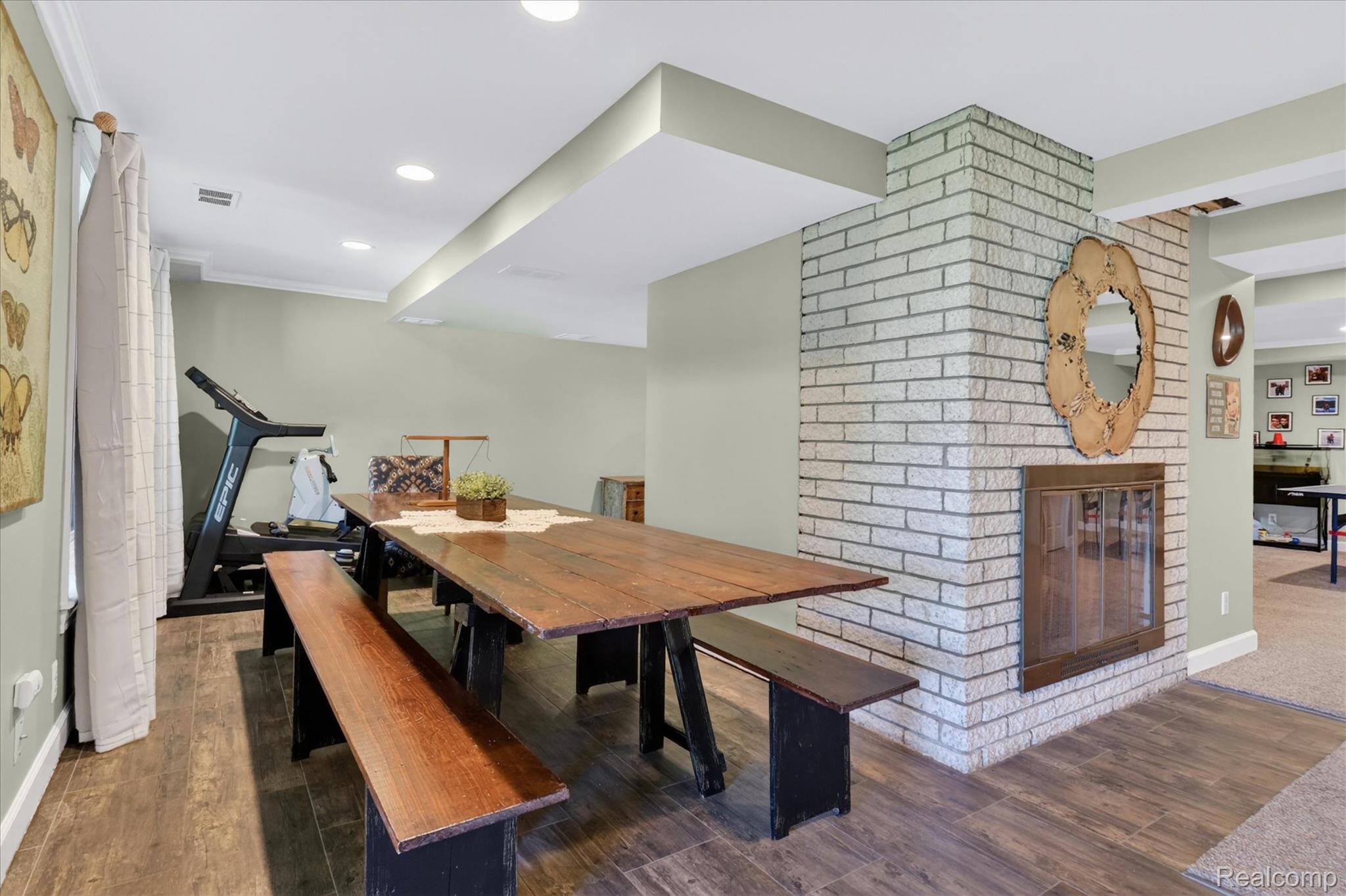 3860 East Commerce Road Commerce Township, MI 48382 - Photo 42 of 72 Brick fireplace with a glass enclosure, wood-finish flooring, and recessed lighting