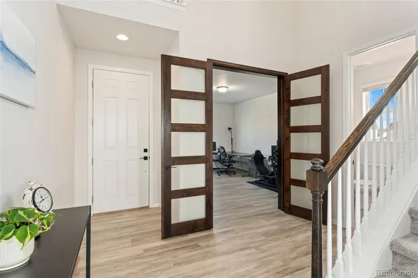 a view of a hallway with wooden floor and furniture