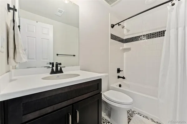 a bathroom with a sink vanity mirror and toilet