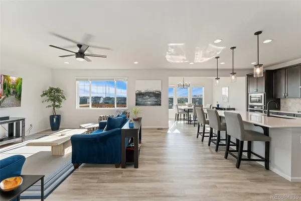 a living room with furniture kitchen view and a chandelier