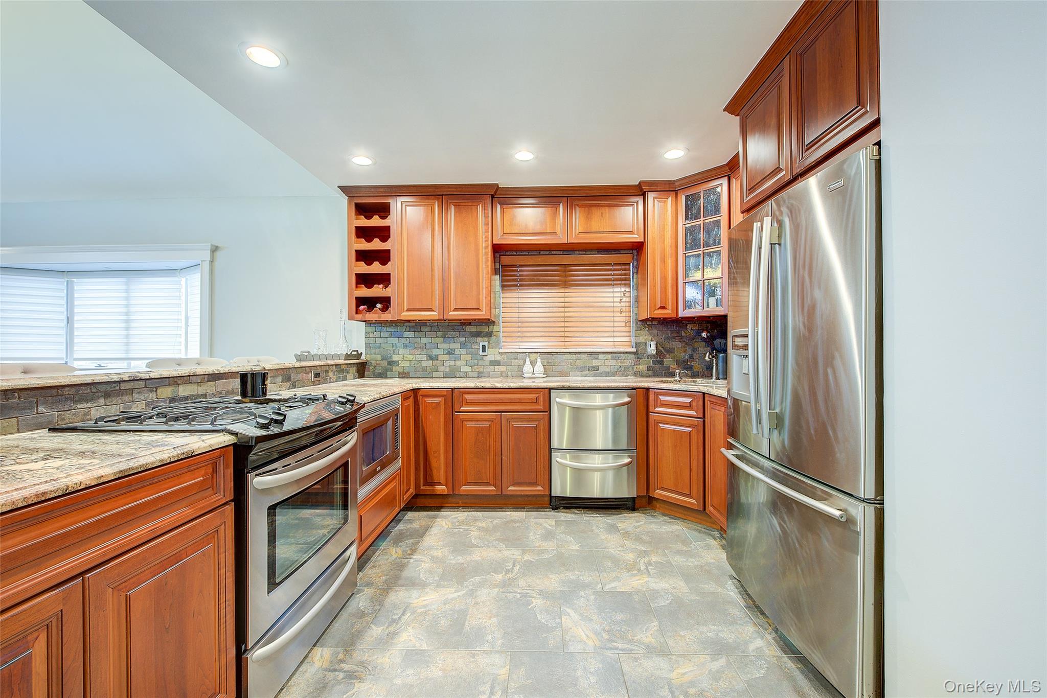 161 Beach 128th Street, Unit 1B Queens, NY 11694 - Photo 12 of 36 a kitchen with stainless steel appliances granite countertop a refrigerator and a stove top oven
