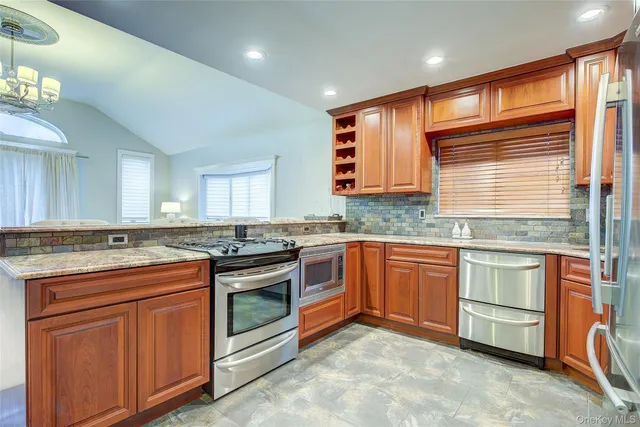 a kitchen with stainless steel appliances granite countertop a refrigerator and a stove top oven
