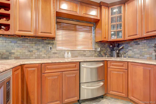 a kitchen with stainless steel appliances kitchen island granite countertop a refrigerator and a sink