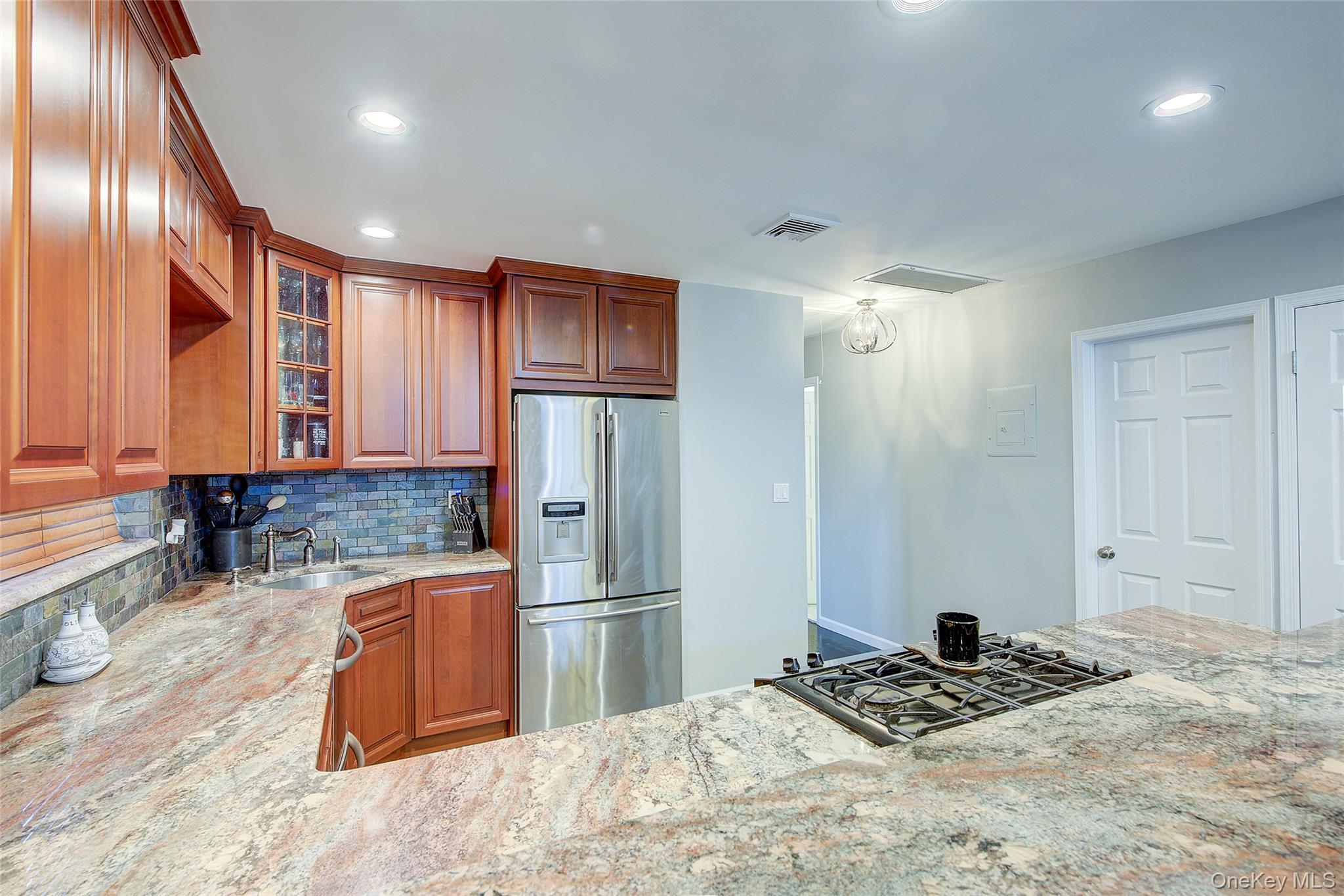 161 Beach 128th Street, Unit 1B Queens, NY 11694 - Photo 17 of 36 a kitchen with stainless steel appliances kitchen island granite countertop a refrigerator and a sink