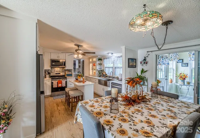 a very nice looking dining room with kitchen island furniture and a chandelier