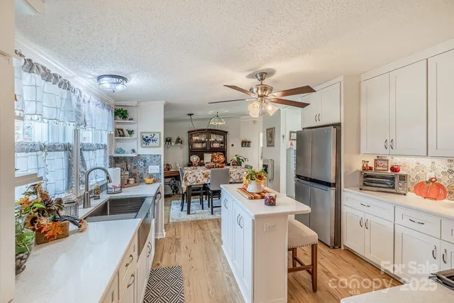 a view of a dining room and a livingroom with furniture a rug a fireplace and a chandelier