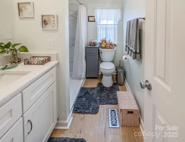 a bathroom with a granite countertop sink toilet and shower