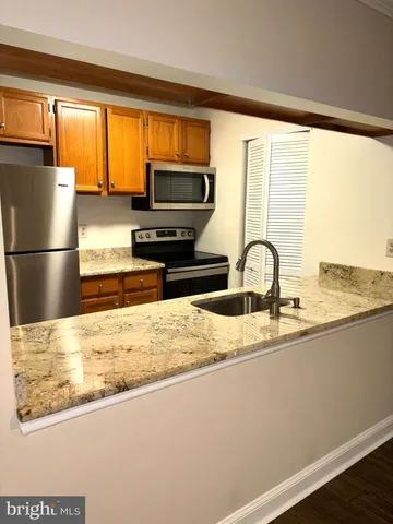 a kitchen with kitchen island a sink appliances and a window