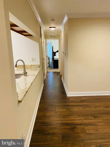 a view of a hallway with wooden floor and staircase