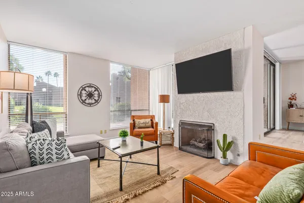 a living room with furniture a flat screen tv and a fireplace