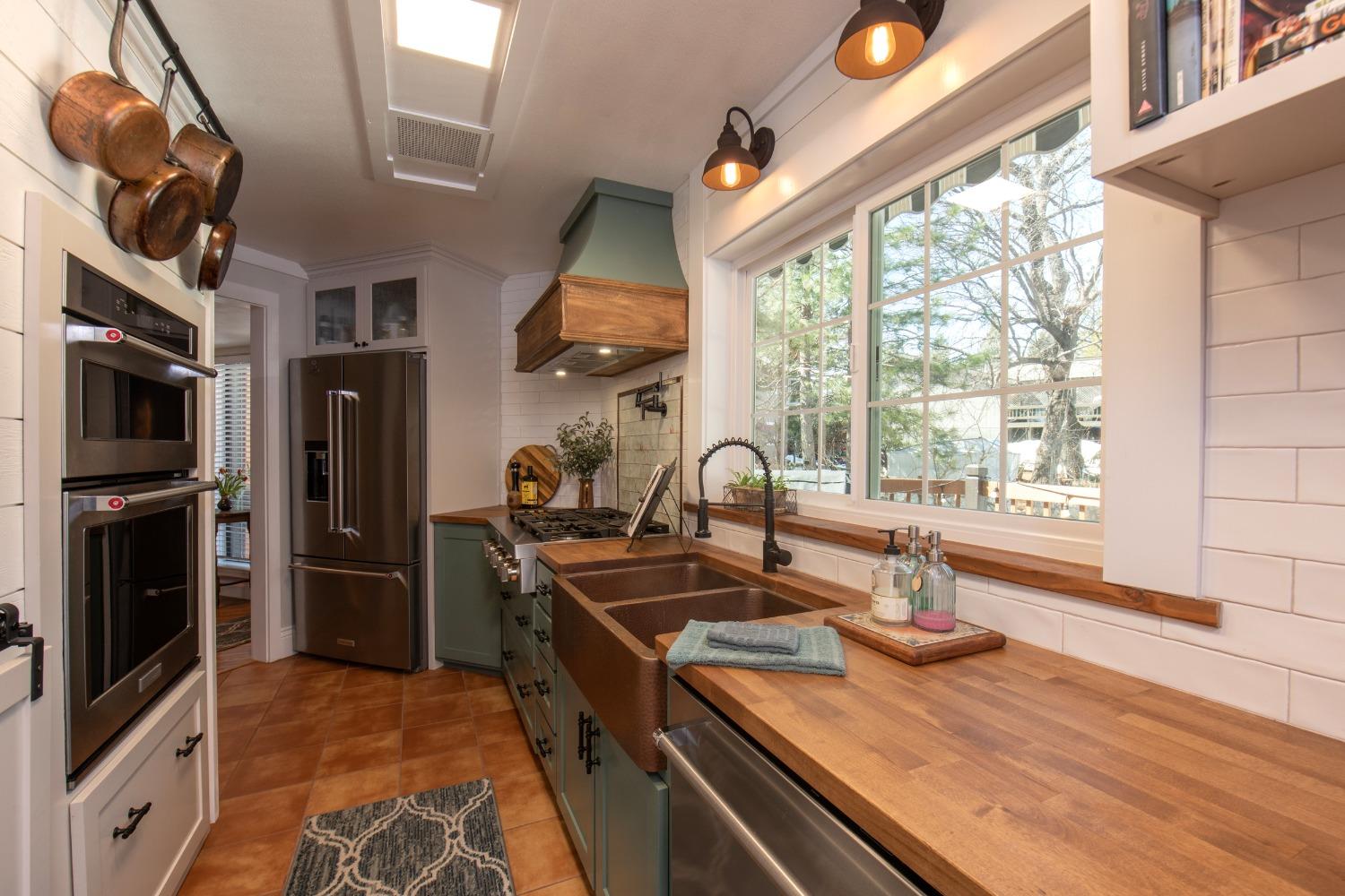 33952 Tocaloma Road Auberry, CA 93602 - Photo 13 of 48 a kitchen with stainless steel appliances granite countertop a sink stove and refrigerator