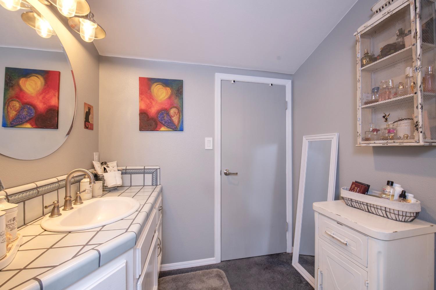 33952 Tocaloma Road Auberry, CA 93602 - Photo 31 of 48 a bathroom with a sink a vanity and a mirror