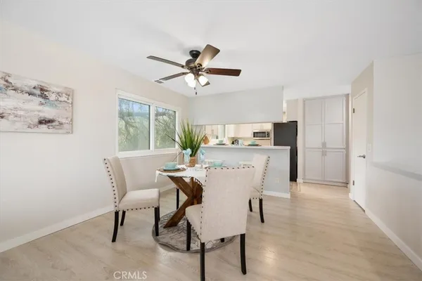 a view of a dining room with furniture and a chandelier fan