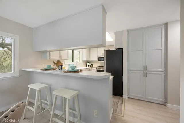 a kitchen with a sink a refrigerator and cabinets