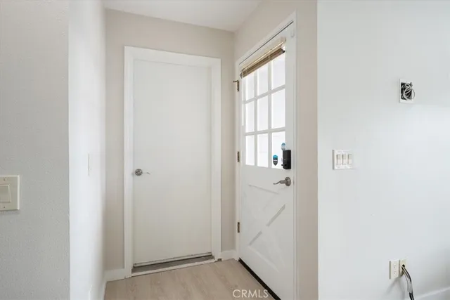 a view of a hallway with wooden floor and entryway