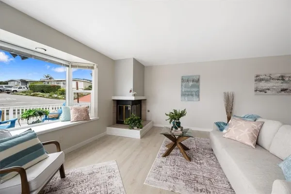 a living room with furniture a rug and a floor to ceiling window