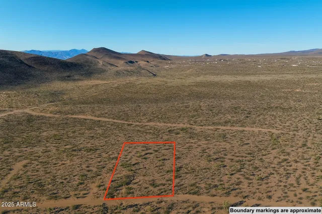 a view of a dry yard with mountains in the background