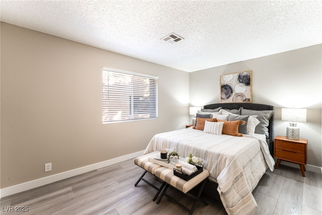 3151 North Soaring Gulls Drive, Unit 1188 Las Vegas, NV 89128 - Photo 12 of 43 Bedroom with a textured ceiling and light wood-style flooring