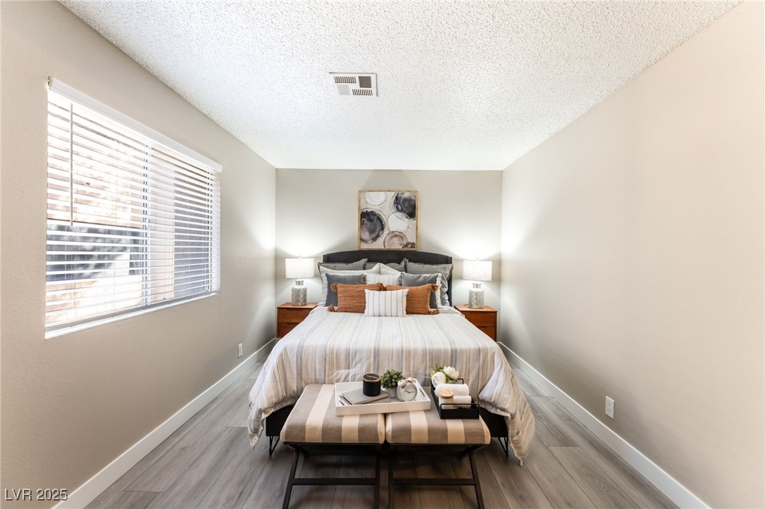 3151 North Soaring Gulls Drive, Unit 1188 Las Vegas, NV 89128 - Photo 14 of 43 Bedroom with wood finished floors and a textured ceiling