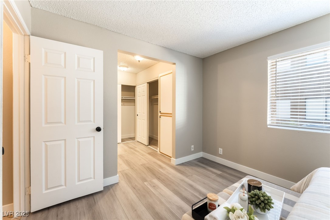 3151 North Soaring Gulls Drive, Unit 1188 Las Vegas, NV 89128 - Photo 16 of 43 Living area with a textured ceiling and light wood-type flooring
