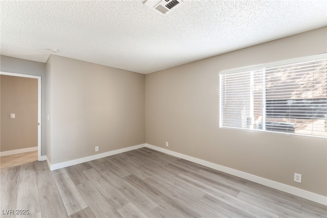 3151 North Soaring Gulls Drive, Unit 1188 Las Vegas, NV 89128 - Photo 22 of 43 Spare room featuring light wood finished floors and a textured ceiling