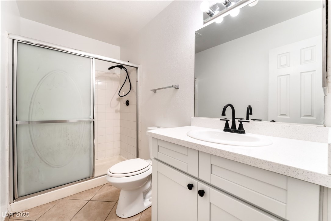 3151 North Soaring Gulls Drive, Unit 1188 Las Vegas, NV 89128 - Photo 23 of 43 Full bathroom featuring vanity, light tile patterned flooring, and a stall shower
