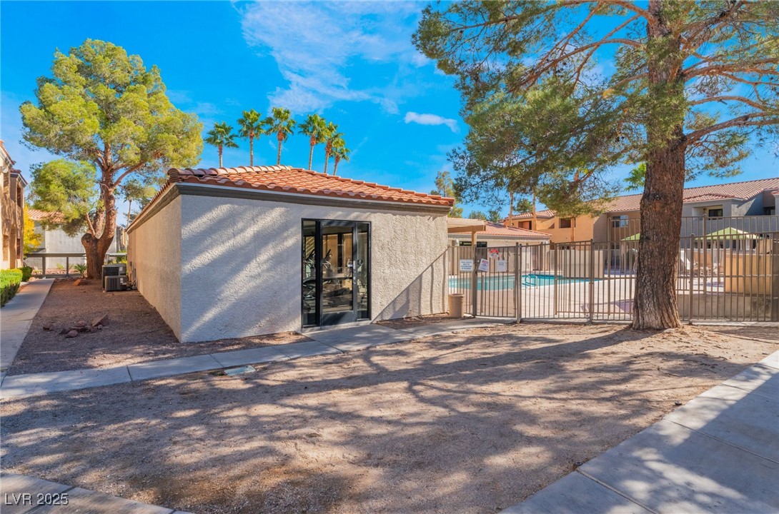 3151 North Soaring Gulls Drive, Unit 1188 Las Vegas, NV 89128 - Photo 34 of 43 Rear view of property with a community pool, stucco siding, and a tiled roof