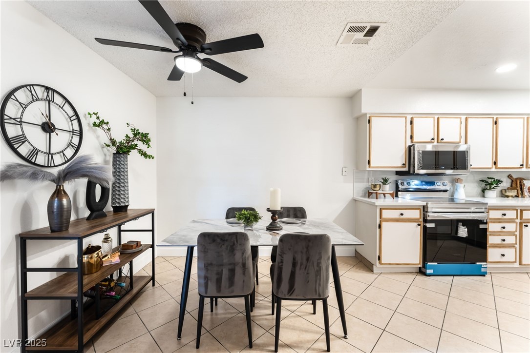 3151 North Soaring Gulls Drive, Unit 1188 Las Vegas, NV 89128 - Photo 7 of 43 Dining space with light tile patterned floors, a textured ceiling, and a ceiling fan