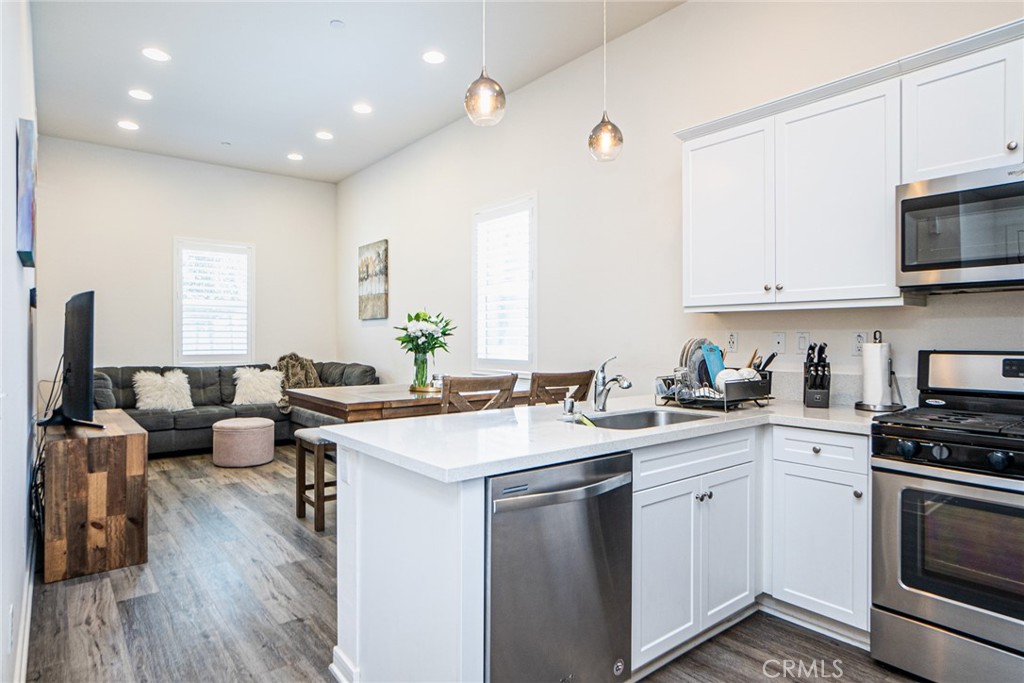 4956 Arrow, Unit B Montclair, CA 91763 - Photo 14 of 35 a kitchen with a sink stove cabinets and wooden floor