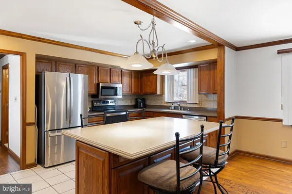 a kitchen with a table chairs refrigerator and microwave