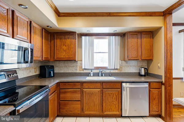 a kitchen with granite countertop cabinets stainless steel appliances a sink and a window