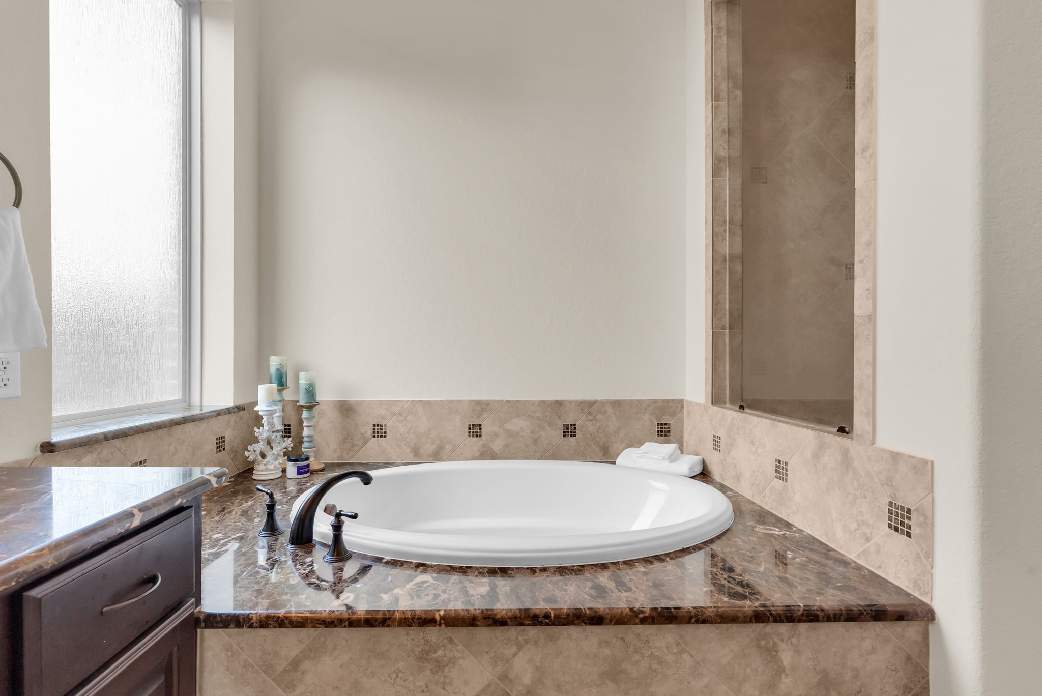 4022 Sabine Valley Trail Spring, TX 77386 - Photo 20 of 46 This bathroom features a luxurious corner soaking tub with elegant marble surrounds and modern fixtures. A frosted window provides natural light while ensuring privacy.