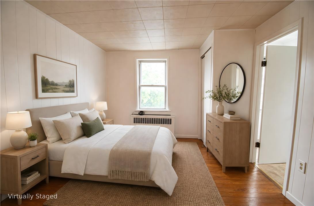 27 West Allen Street Allentown, PA 18102 - Photo 15 of 26 A comforting bedroom features warm wood flooring and paneling, with an inviting window allowing natural light.