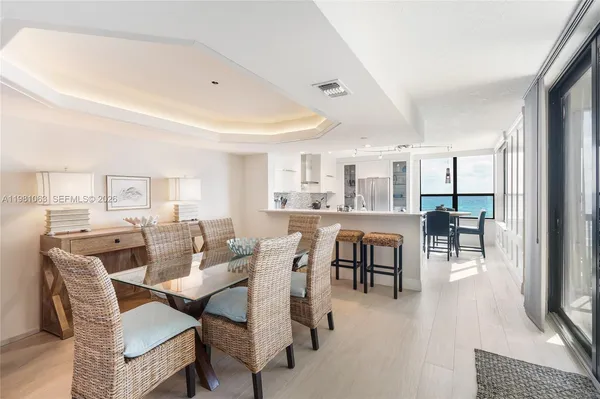 a view of a dining room with furniture a chandelier and wooden floor