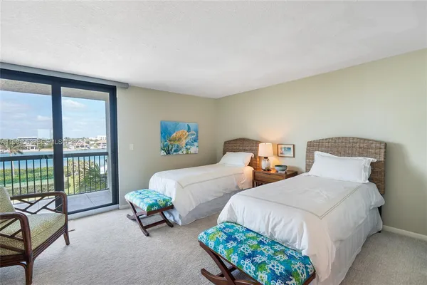 a bedroom with two beds and large window