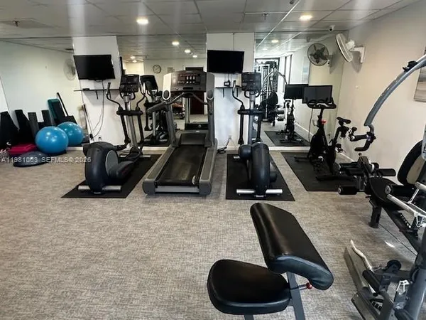 a room with gym equipment and a flat screen tv