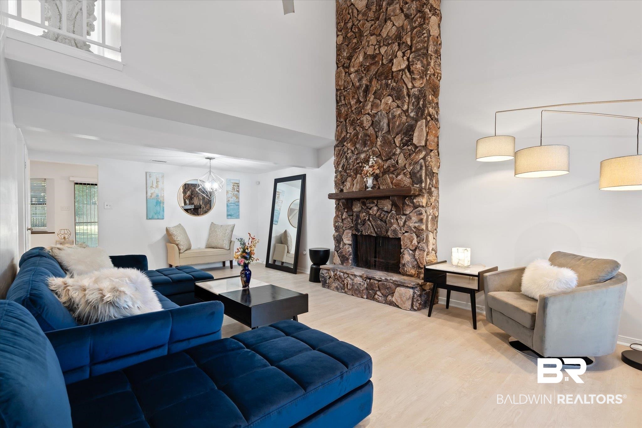 1008 Mcneil Avenue Mobile, AL 36609 - Photo 3 of 20 Living room with a fireplace, hardwood / wood-style floors, a towering ceiling, and a notable chandelier