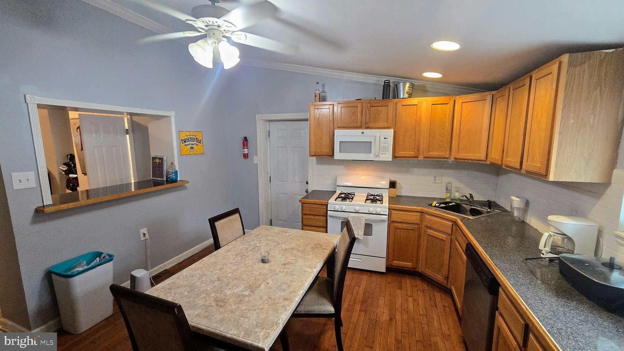 4709 Fowler Street Philadelphia, PA 19127 - Photo 5 of 21 a kitchen with stainless steel appliances granite countertop a stove top oven a sink a dining table and chairs with wooden floor