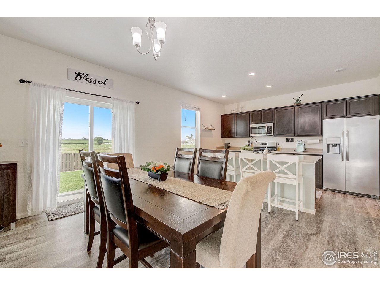 327 Central Avenue Severance, CO 80550 - Photo 12 of 40 a view of a dining room with furniture and wooden floor