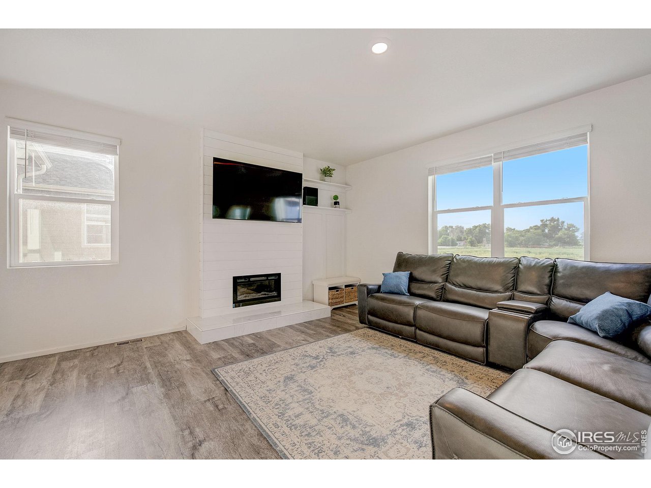 327 Central Avenue Severance, CO 80550 - Photo 7 of 40 a living room with furniture a flat screen tv and a fireplace