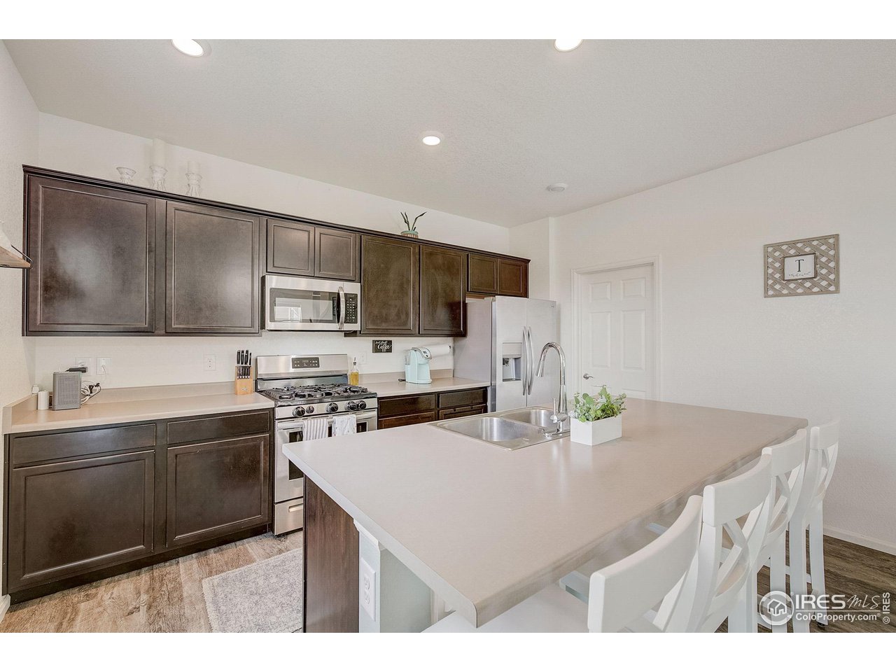 327 Central Avenue Severance, CO 80550 - Photo 10 of 40 a kitchen with a sink a stove a refrigerator and white cabinets
