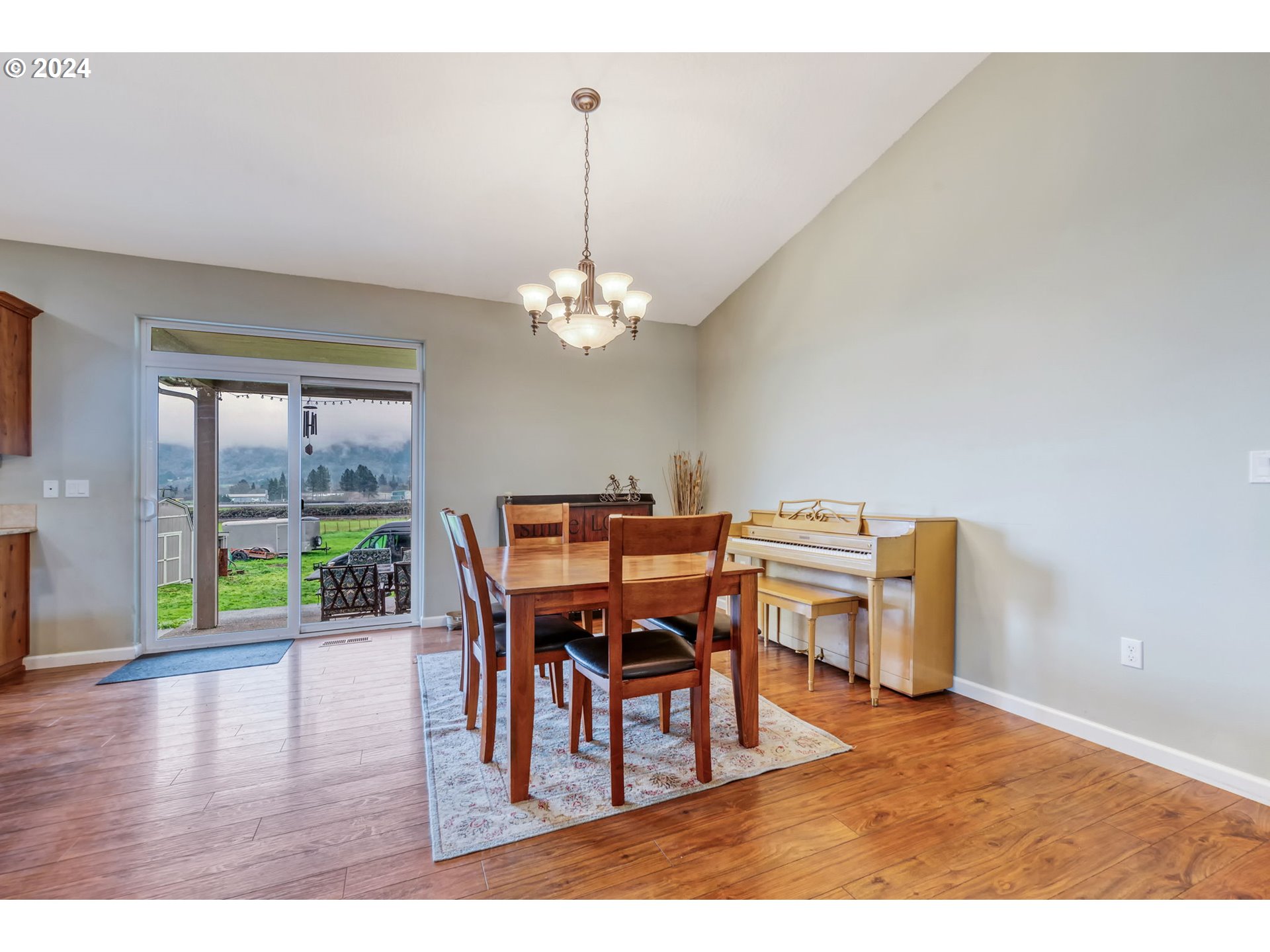1032 Weaver Road Myrtle Creek, OR 97457 - Photo 6 of 42 a dining room with furniture a chandelier and wooden floor