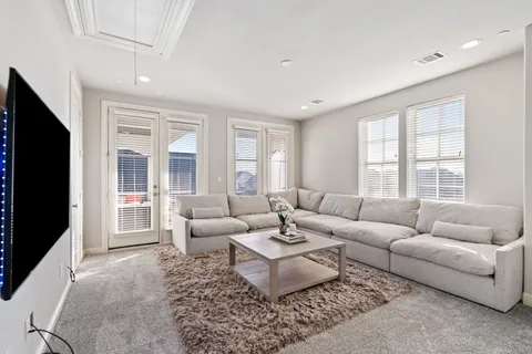 a living room with furniture windows and a flat screen tv
