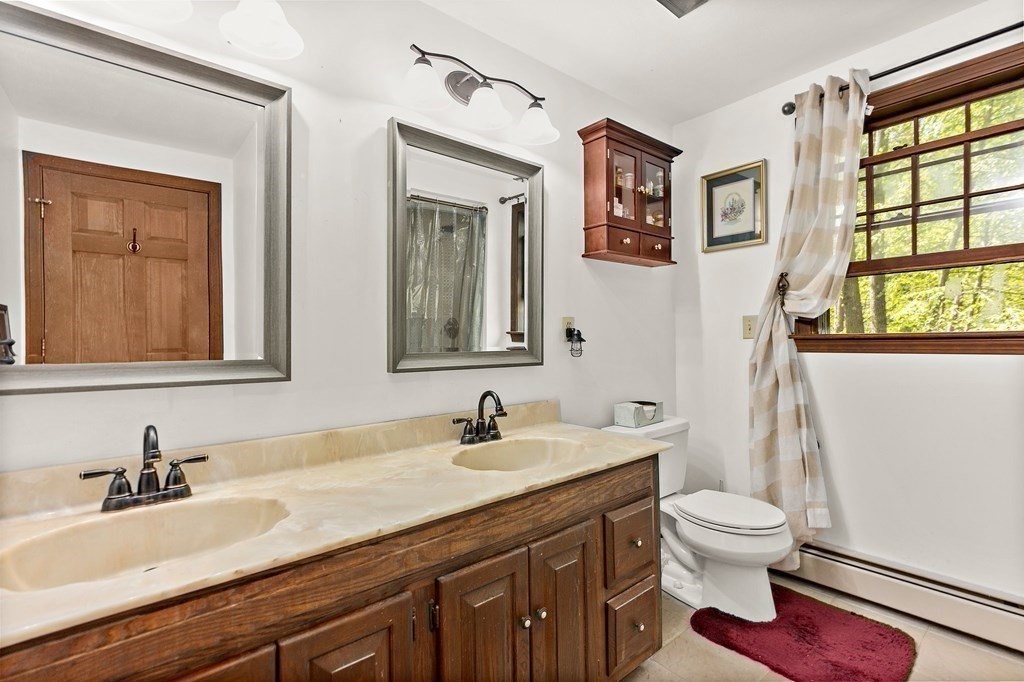 41 Baker Road Salisbury, MA 01952 - Photo 20 of 29 a bathroom with a granite countertop sink toilet a large mirror and a window