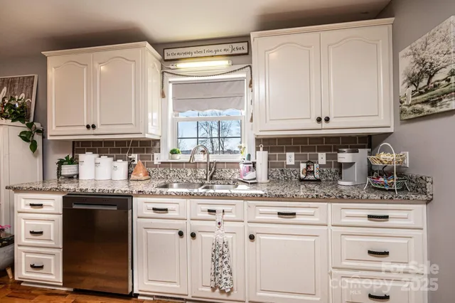 a kitchen with granite countertop white cabinets and white appliances