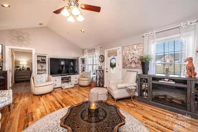 a living room with furniture a flat screen tv and a large window